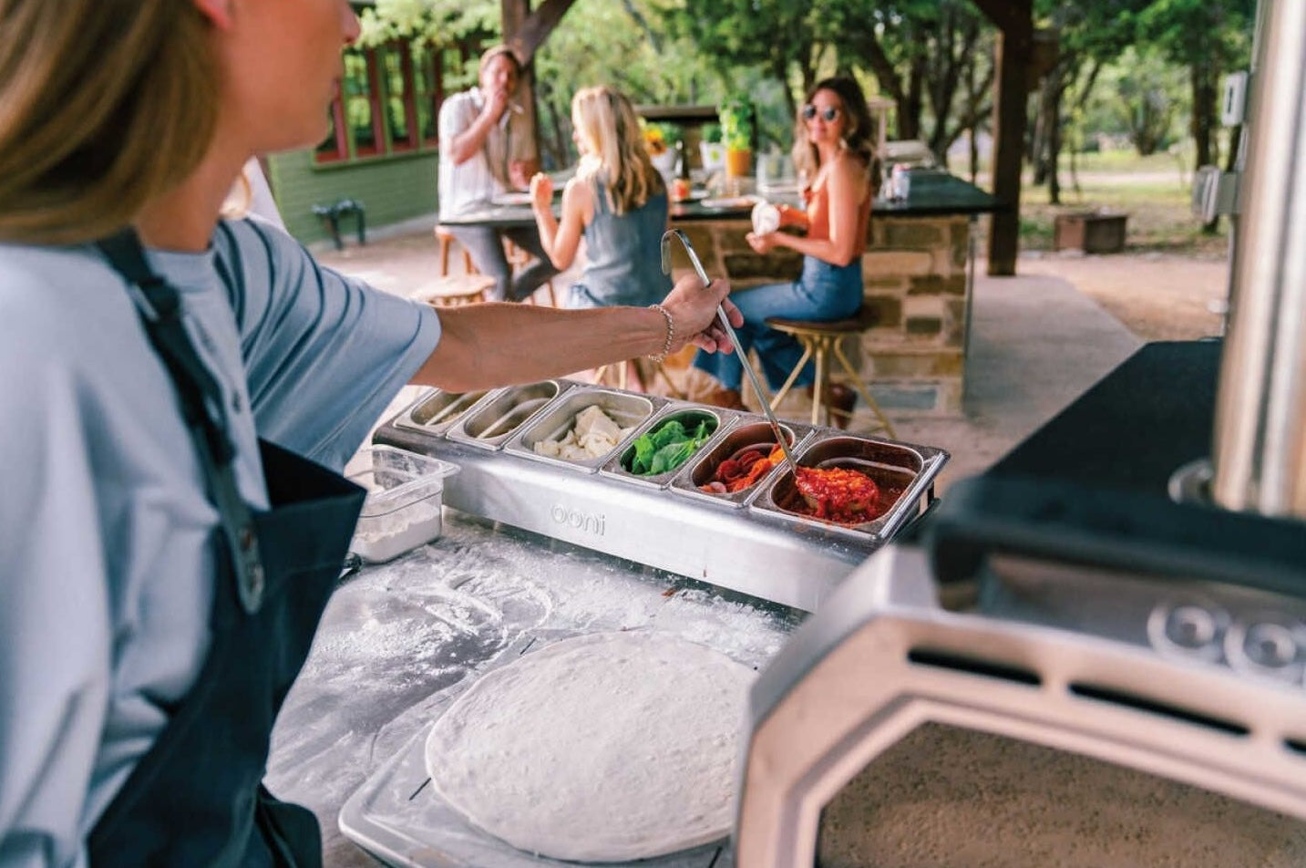 Compact outdoor pizza topping station with six clear containers for fresh ingredients in grilling and outdoor living spaces