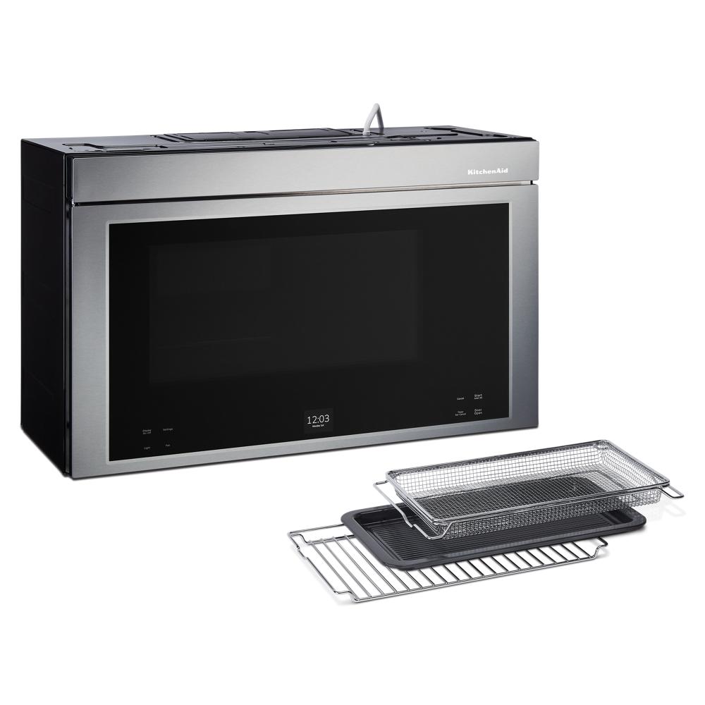 Stainless steel multifunction over-the-range microwave oven with air fryer basket and trays on white background