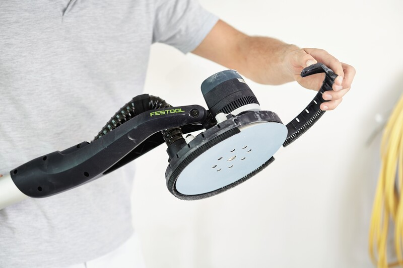 Person holding a black Festool power sander with flexible handle for tools and home improvement tasks