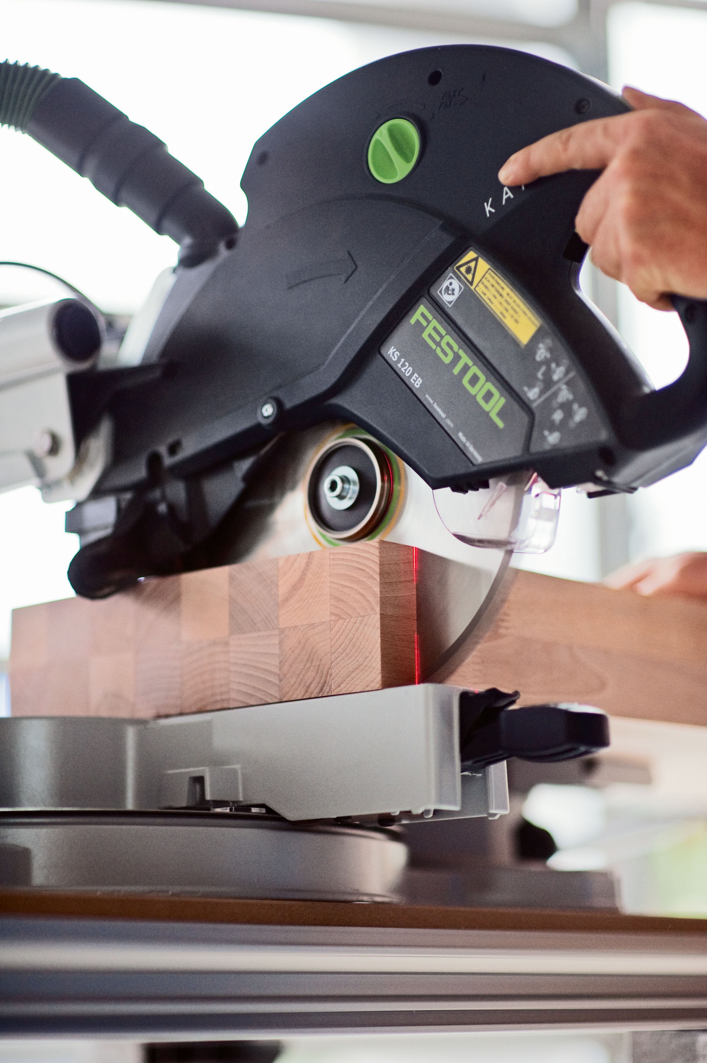 Close-up of Festool sliding compound miter saw cutting wood with laser guide in Power Tools and Festool Saws collections