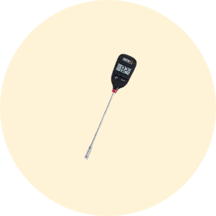 Digital cooking thermometer with a long metal probe and an LCD screen displaying temperature readings on a light beige circular background.