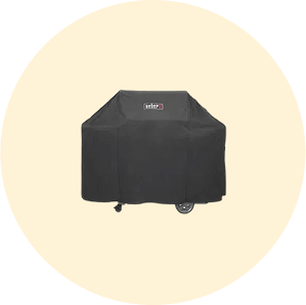 Black protective cover draped over a wheeled grill with a visible logo on the front against a soft beige circular background.